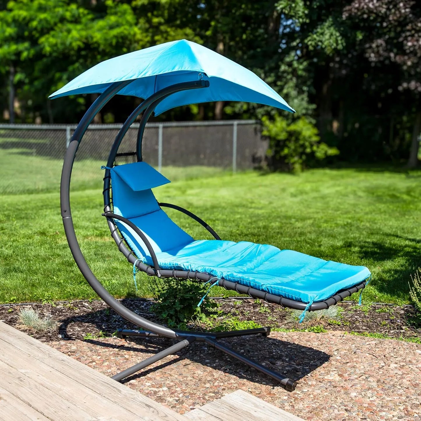 Curved steel hammock lounge chair with cushions and pillows