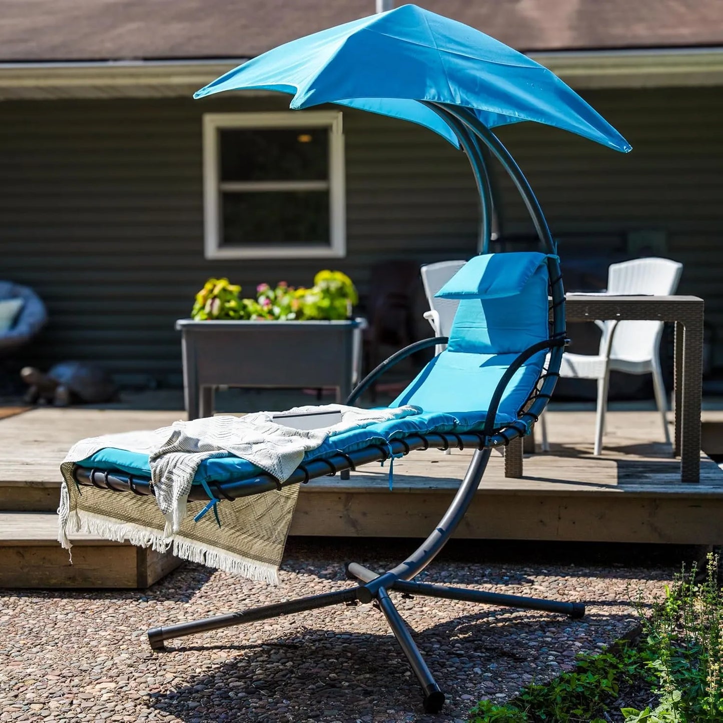 Curved steel hammock lounge chair with cushions and pillows